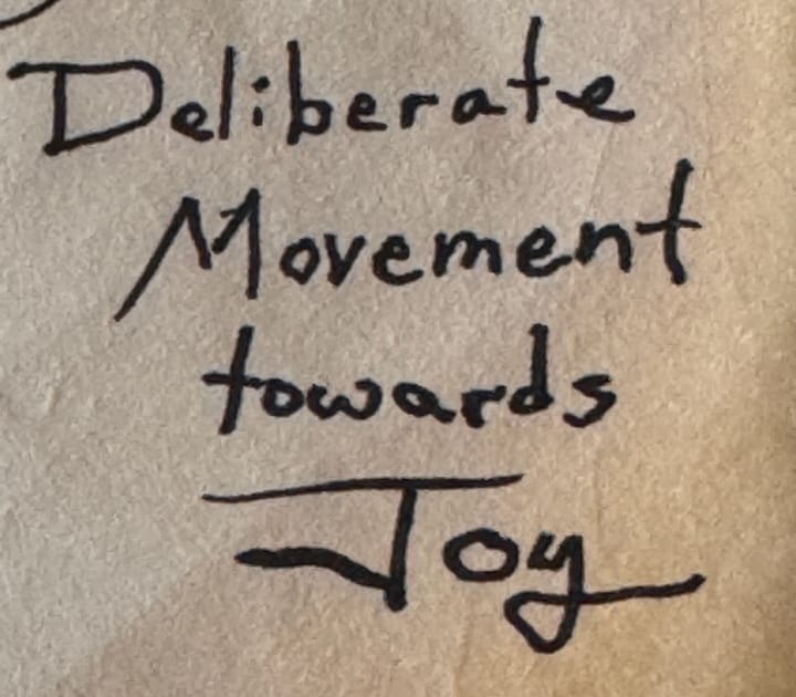 Handwriting that shows the words “Deliberate Movement towards Joy.”